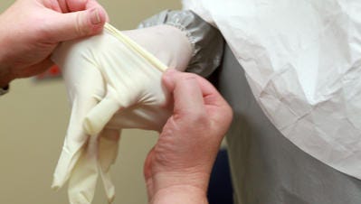A fake Ebola case was reported in Dayton. Double-gloving is among the precautions taken by medical personnel when dealing with patients suspected of having Ebola.