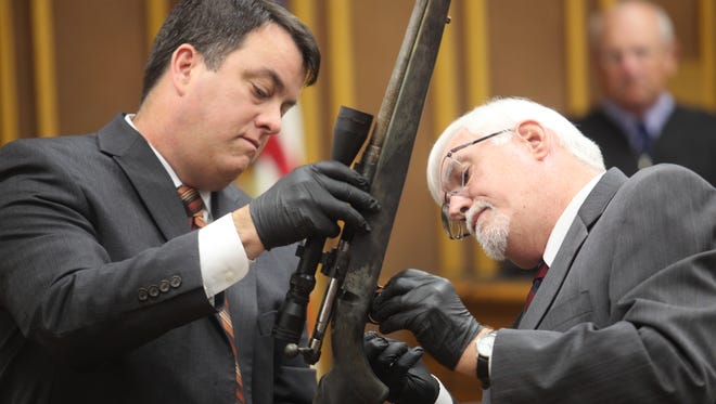 Assistant Iowa Attorney General Scott Brown and state criminalist Carl Bessman show jurors a .223-caliber rifle that prosecutors say killed Rockwell City police officer Jamie Buenting