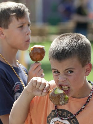 Jake Costa, 10, right, and Josh Kuehl, 10 eat caramel apples at the Tulare County Fair.