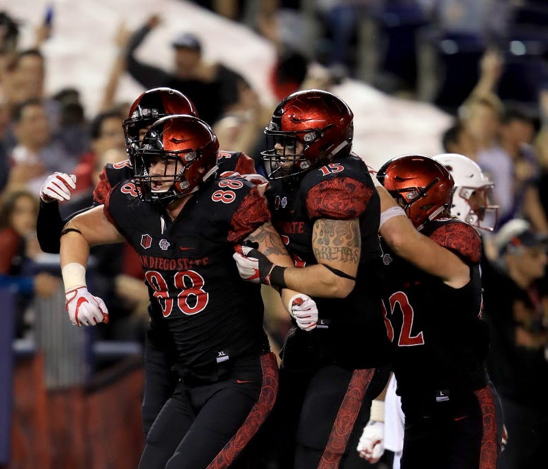 Tim Wilson Jr. (93) and Nick Bawden (15) congratulate David Wells (88) after he scored the game-winning touchdown for San Diego State.