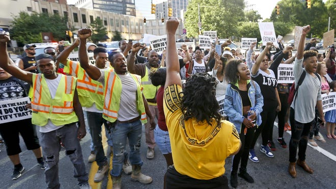 Marchers raise their fists as they protest the shooting death of Antwon Rose Jr. on Tuesday, June 26, 2018 in Pittsburgh. Rose was fatally shot by a police officer seconds after he fled a traffic stop June 19, in the suburb of East Pittsburgh. (AP Photo/Keith Srakocic)