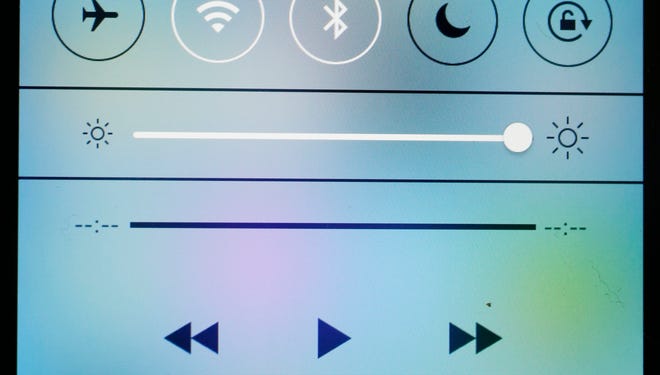 An iPhone with iOS 7 software displays the new look of the Control Center.