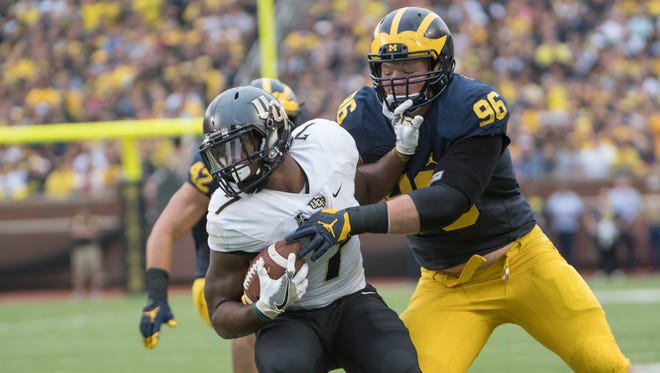 Michigan defensive tackle Ryan Glasgow wraps up Central Florida running back Dontravious Wilson.