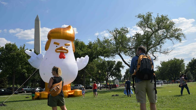 An inflatable chicken mimicking US President Donald Trump is set up on The Ellipse,  a 52-acre (21-hectare) park located just south of the White House and north of the Washington Monument (rear).