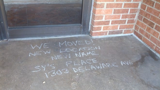 A note written in sidewalk chalk tells of a new name and location for the former Temptations deli in Wilmington. The Trolley Square restaurant moved a few blocks away and is now named Sy's Place.
