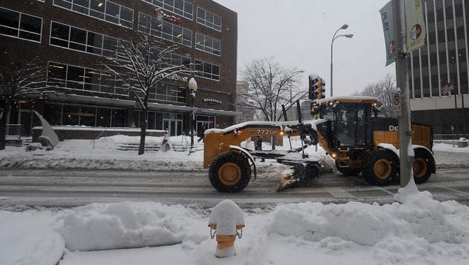 Snow plows clear the roads along Phillips Avenue in downtown Sioux Falls on Friday, Nov. 20, 2015.
