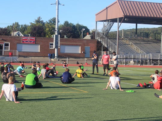 Head coach Jim Tobin talks to the boys soccer team at the end of practice on Monday evening.
