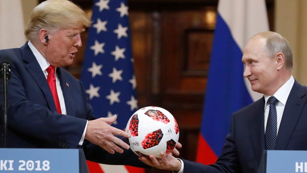 Russian President Vladimir Putin gives a soccer ball