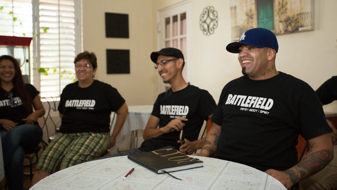 Alfredo Pabon, right, Dee Bernal, center, and other founders of Battlefield sit together discussing T-shirt graphic designs on Thursday, Sept. 15, 2016.
