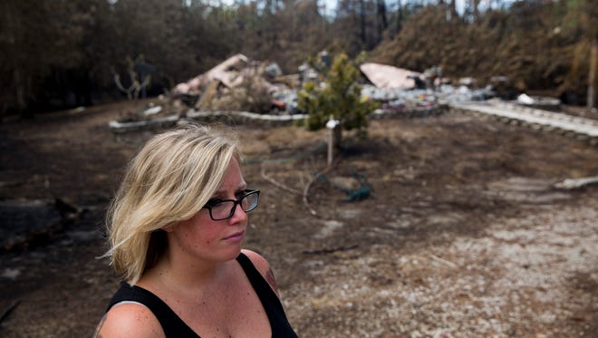 Lindsey Rotondo stands outside the remains of her home in the 2200 block of Kearney Avenue on Monday, April 24, 2017, in Golden Gate Estates. Rotondo, as well as her husband, Tony, and son Antonio III, 4, lost their home to a brush fire while celebrating the couple's seventh wedding anniversary at Magic Kingdom in Orlando.