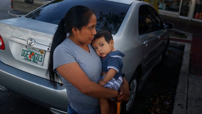Buena Ventura Martin-Godinez, from Guatemala, holds her son, Pedro, as she waits for her brother to cross the street in Homestead, Fla., on Wednesday, June 27, 2018. She came to the U.S. to help her family and ended up having it torn apart instead. Martin carried her infant son from Mexico into the U.S. in May, fleeing what she said were threats from violent local gangsters demanding money in their hometown in northwestern Guatemala. Her husband followed two weeks later with their 7-year-old daughter. All were caught by the Border Patrol.