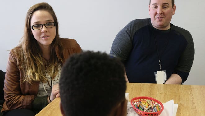 A child in a Milwaukee County mental health program talks with care coordinators Autumn Sparks (left) and Ellis Stephens (right) at the Mental Health Complex.