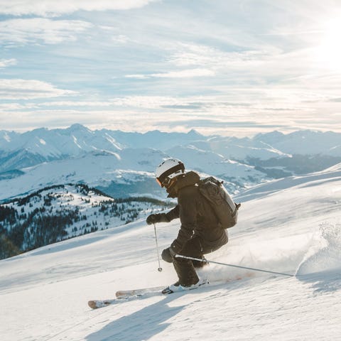 A skiier skis down a mountain.