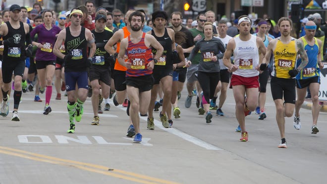 Jason Ryf, far right and wearing a yellow shirt and bib #1292, starts with hundreds of others at 7 a.m. Sunday in downtown Oshkosh. A hometown favorite, Ryf won the 13.1-mile half marathon.