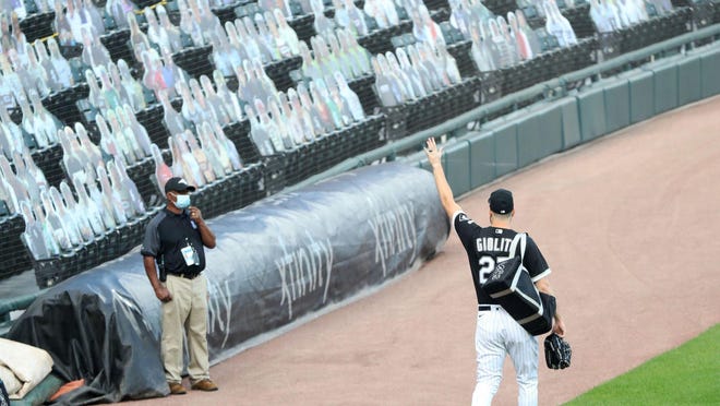 White Sox starting pitcher Lucas Giolito waves to virtual fans, in the form of cutouts, while heading to the bullpen to warm up before the game against the Twins.