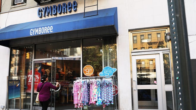 People walk by the children's clothing retailer Gymboree, which has filed for bankruptcy protection on June 13, 2017