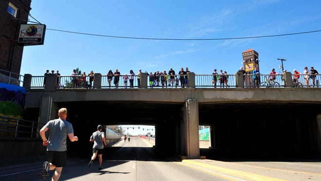 Spectators watch the 3-mile run from the train overpass at 1st Avenue North during the 39th Annual Ice Breaker Road Race last year. Those watching Sunday's race will need to bundle up from the snow, wind and cold temperatures, which aren't supposed to get out of the low-to-mid 30s.