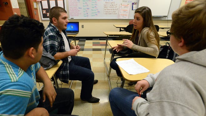 Amy Cochran, second from right, journalism teacher at Amanda-Clearcreek High School, talks to Kevin Hudson, second from left, Alex Martinez, left, and Owen Dunlap about their next video project Friday, Dec. 15, 2017, in Amanda. The three students had previously done a project on the school districts income tax levy that failed to pass in November.