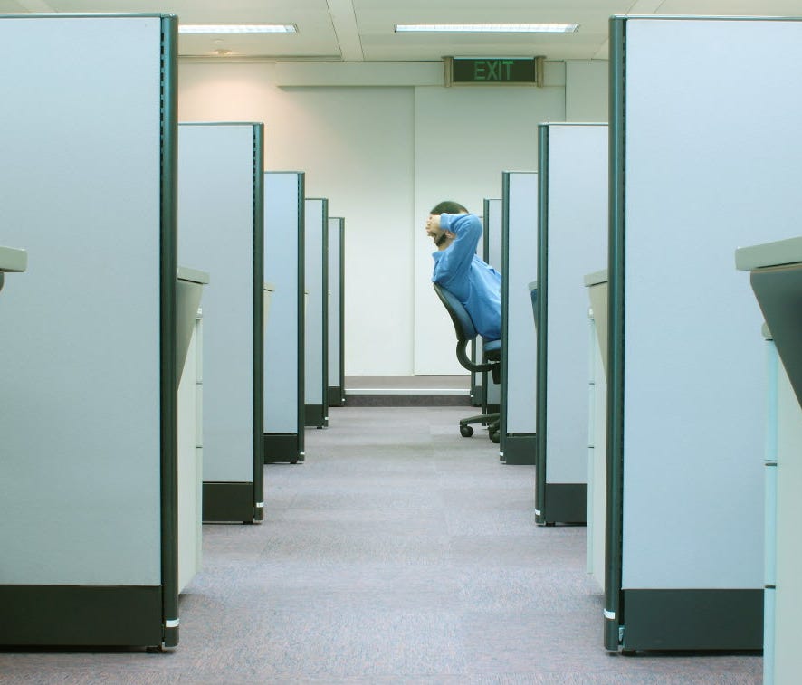 A man sitting at his cubicle.