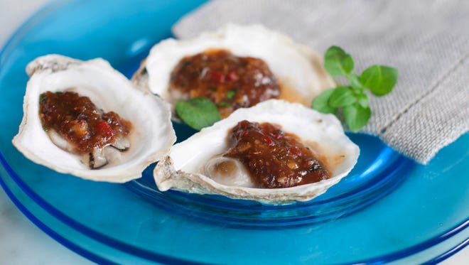 Oysters are shucked, dabbed with black bean and chili garlic sauce, then grilled for a tasty twist on the briny beauties.