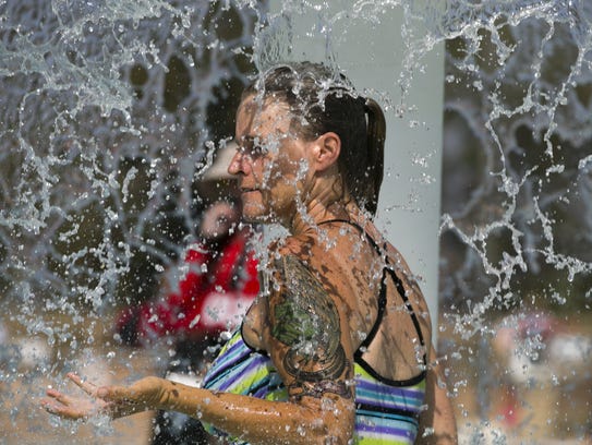 Stacey Stewart of Phoenix cools off in the fountain