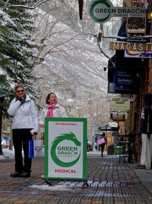 Tourists on Hyman Avenue, a shopping district in Aspen, Colo., peer into a legal marijuana store just a few steps away from stores like Ralph Lauren, Prada and Burberry.