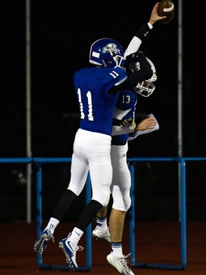Harper Creek teammates celebrate after QB Jackson Malone rushes for a touchdown Friday night.