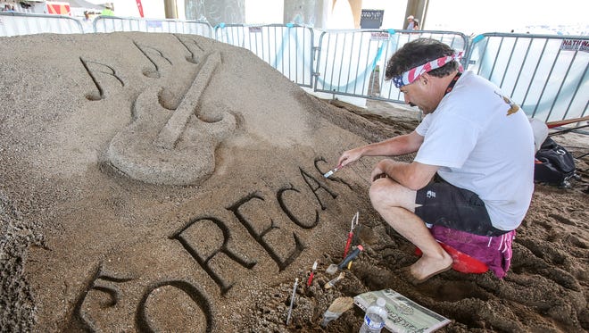Sand artist Les Terwilleger works on a sand sculpture at Forecastle on Saturday.July 15, 2017
