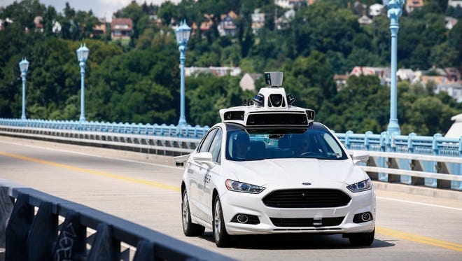 Uber employees test a self-driving car in August 2016.