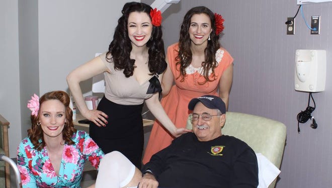 Jennifer Marshall, Gina Elise and Shannon Corbeil pose with a veteran during a March visit to a VA Hospital in North Las Vegas, Nev. Supporters of Elise's group, "Pin-Ups for Vets," have lashed out at the Sioux Falls VA for rescinding its welcome to the group.