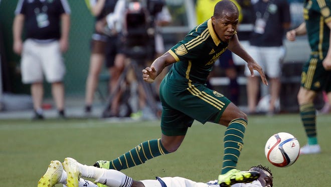 Portland Timbers forward Darlington Nagbe, top, leaps over Vancouver Whitecaps midfielder Gershon Koffie as he chases the ball during the first half of an MLS soccer game in Portland, Ore. Nagbe is back with Portland for their match against Dallas after his first call up to the U.S. national team.