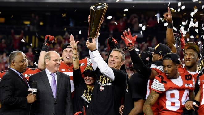 Ohio State head coach Urban Meyer holds up the national championship trophy.