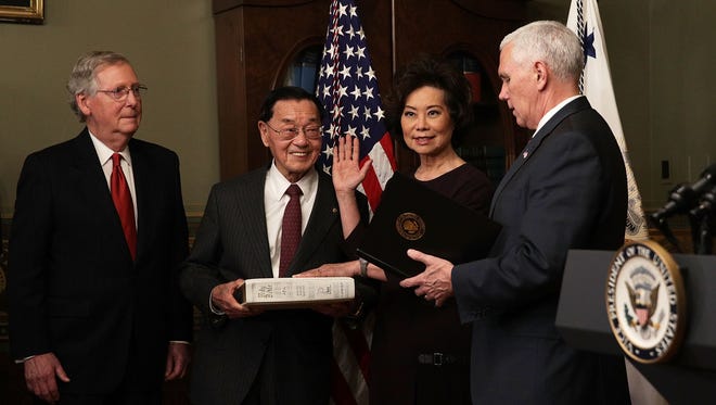 Elaine Chao is sworn in as Transportation secretary by Vice President Pence, accompanied by her father, James Chao, and her husband, Senate Majority Leader Mitch McConnell.