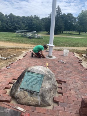 Scout Michael Rotondo III, 14,  works on the brick walkway surrounding the World War II veterans memorial at Memorial Field in Rutland.