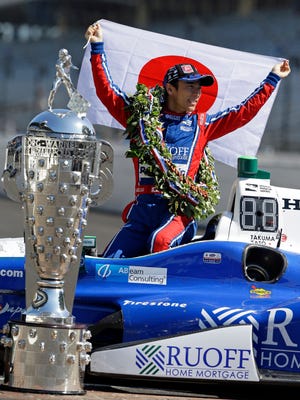 Indianapolis 500 champion Takuma Sato, of Japan, poses with the Borg-Warner Trophy during the traditional winners photo session on the start/finish line at the Indianapolis Motor Speedway in Indianapolis, Monday, May 29, 2017.