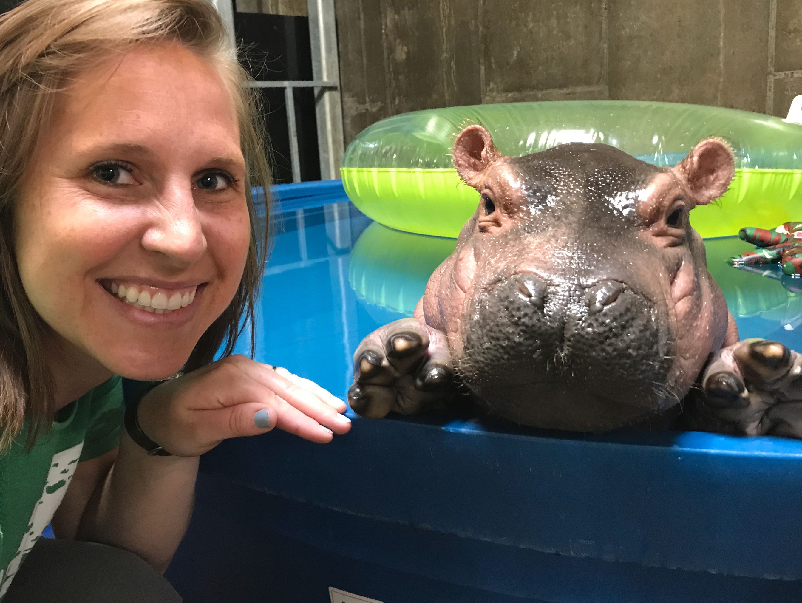 Cincinnati zookeeper Wendy Rice poses in nApril 2017 with Fiona, a Nile hippo born prematurely Jan. 24, 2017, at Cincinnati Zoo & Botanical Garden.