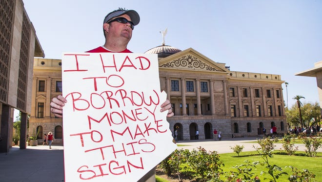 J.R. Krumland, a special education teacher at Deer Valley High School holds his sign at the State Capitol in Phoenix on March 28, 2018, as part of the Arizona Day of Action event. Hundreds of teachers and their supporters gathered to push for better pay for teachers in Arizona.