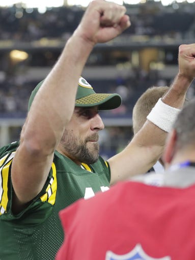 Green Bay Packers quarterback Aaron Rodgers (12) raises