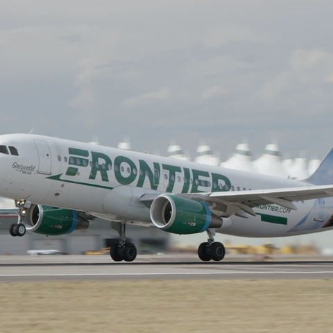 A Frontier Airlines plane landing on a runway.