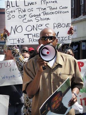 Robert Jones speaks during a 2015 rally in Martinsburg, West Virginia protesting the March 13, 2013 killing of Jones' brother, Winchester, Virginia resident Wayne Jones, by five Martinsburg Police officers. Robert Jones is holding a photograph of his late brother, Wayne Jones.