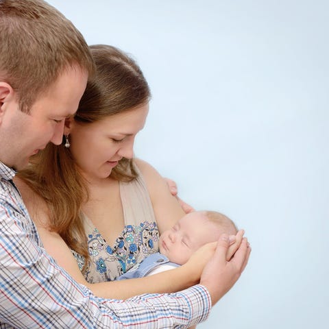 Two parents holding their newborn baby.