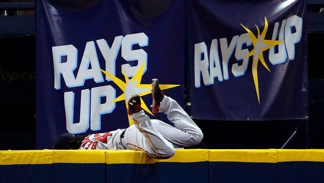 Boston Red Sox left fielder Andrew Benintendi (40) falls into the wall as he catches the ball during the eighth inning against the Tampa Bay Rays at Tropicana Field.