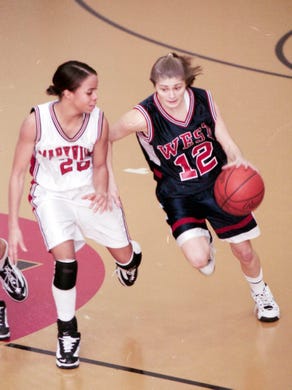 West High School's Natalie Bryant takes the ball up court while defended by Maryville High School's Nikki Porter in February 1999.