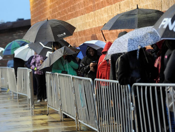 People wait patiently in the rain for Black Friday