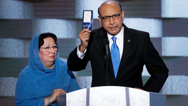 Khizr Khan, father of fallen US Army Capt. Humayun S. M. Khan holds up a copy of the Constitution of the United States as his wife listens during the final day of the Democratic National Convention in Philadelphia.