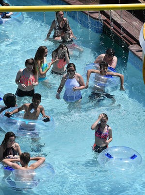 People move under a water spray bar while floating along on Nellie's Rolling River, one of ten major features at Castaway Cove Waterpark.