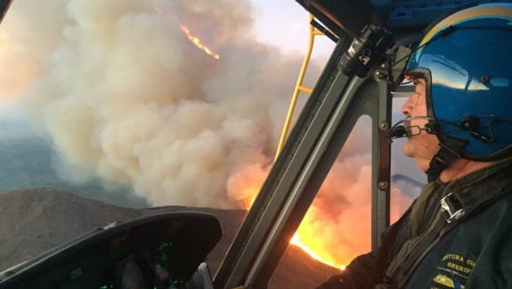 Pilot Jim Dalton and crew, Ventura County Aviation Unit's Copter 7, fight a fire northwest of Ventura, Calif.