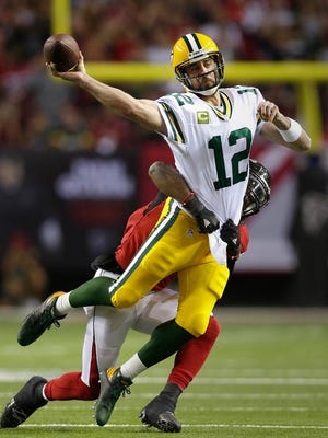 Green Bay Packers quarterback Aaron Rodgers (12) is hit as he released an incomplete pass in the end zone in the first half during the NFC Championship game between the  Green Bay Packers and the Atlanta Falcons, Sunday, January 22, 2016 at the Georgia Dome in Atlanta, Georgia.