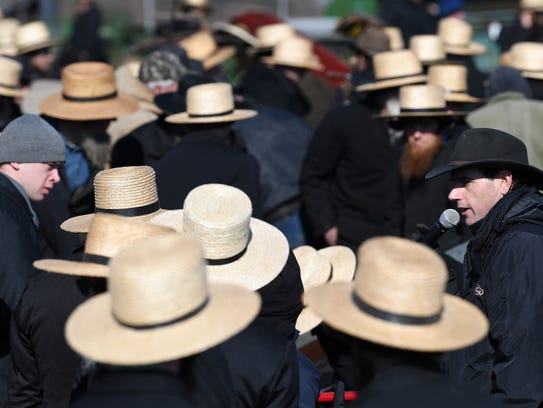 Framed up by a group of Amish, an auctioneer calls out an item up for bid during a mud sale in Gordonville, Pa., on Saturday, March 10, 2018. The annual event, which helps raise money for volunteer fire companies, offers indoor and outdoor auctions, selling items from buggies and farm equipment to horses.