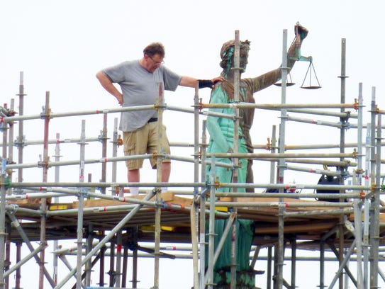 Doug Sheridan of Sunspots Studios stands on scaffolding